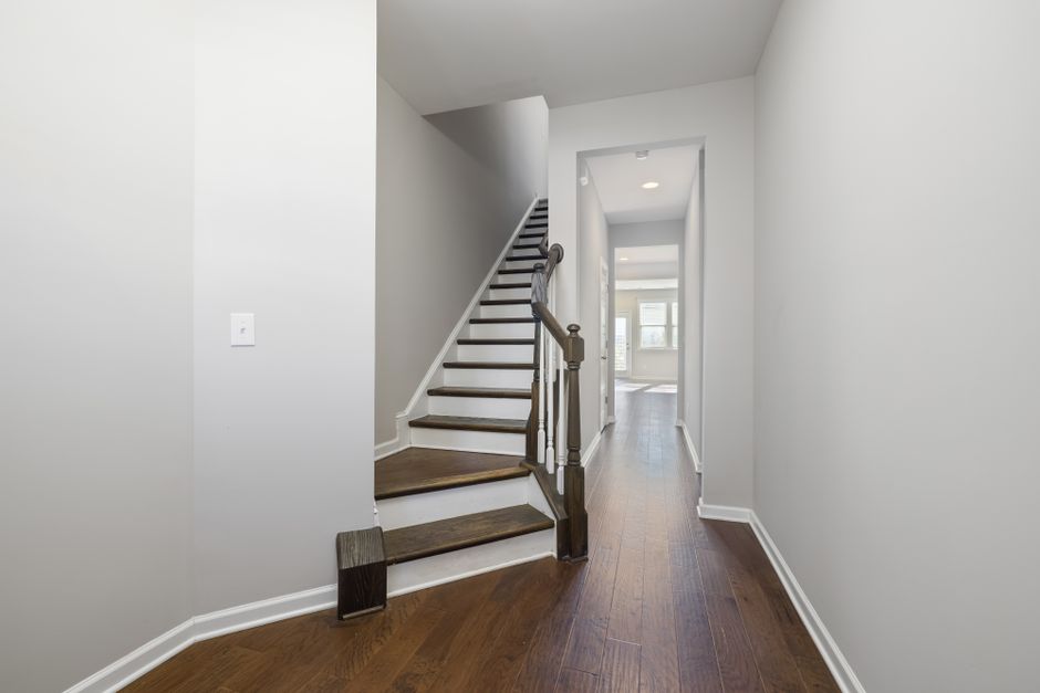 Contemporary hallway with wooden flooring and sleek staircase, perfect for modern homes.